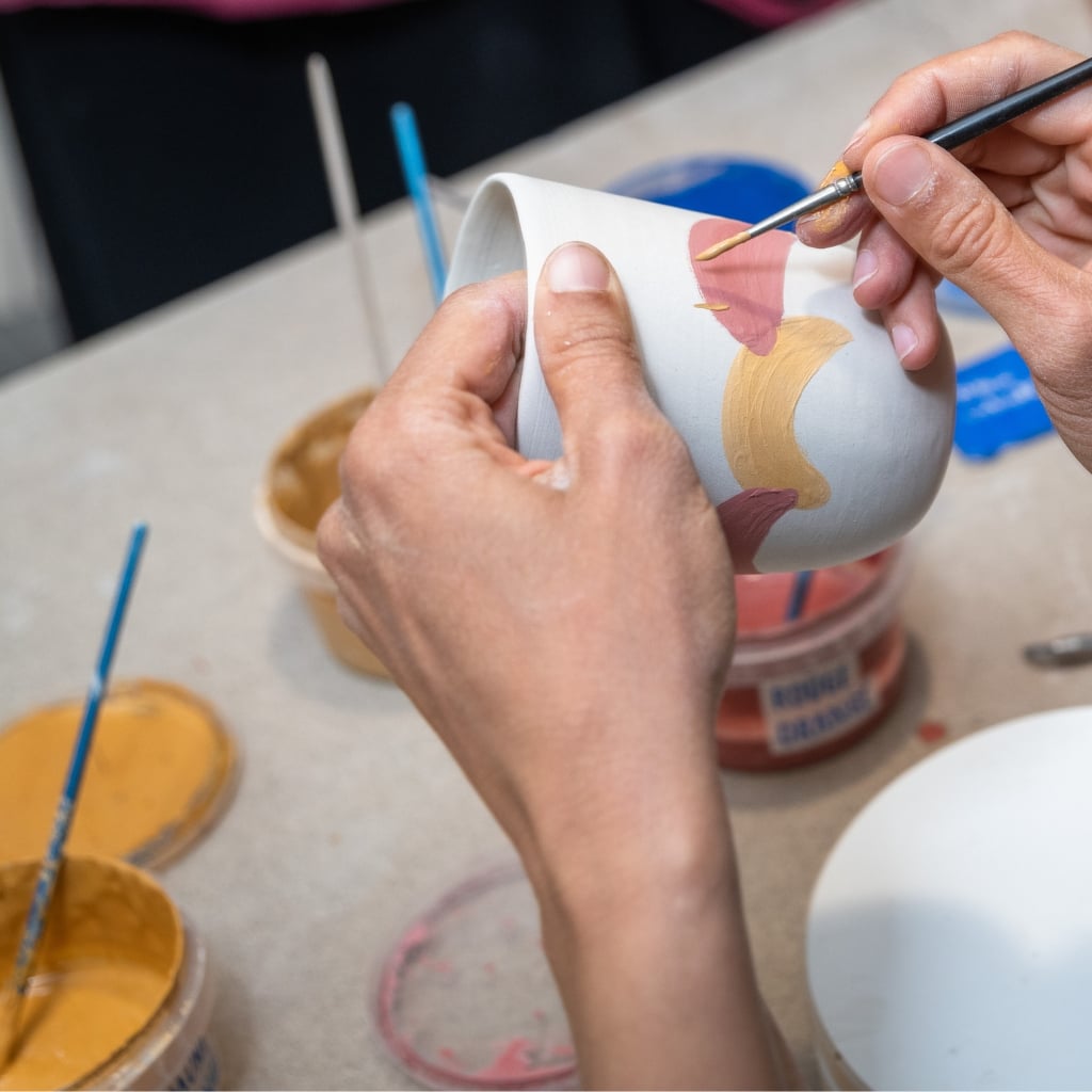 Deltager maler på keramik kop til keramik workshop for virksomheder eller private.