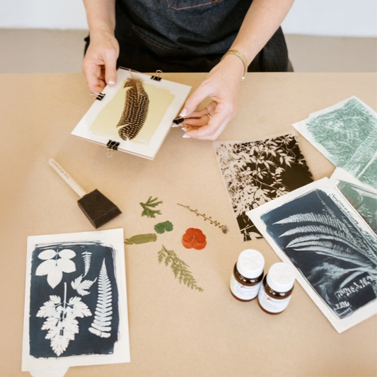 Deltager på kreativ workshop for virksomheder laver solprint (cyanotypi)