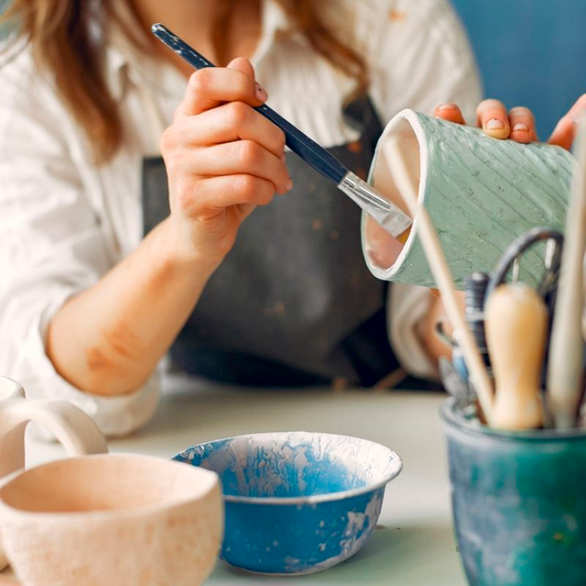 Kursist maler en kop til kreativ keramik workshop, polterabend eller firmafest