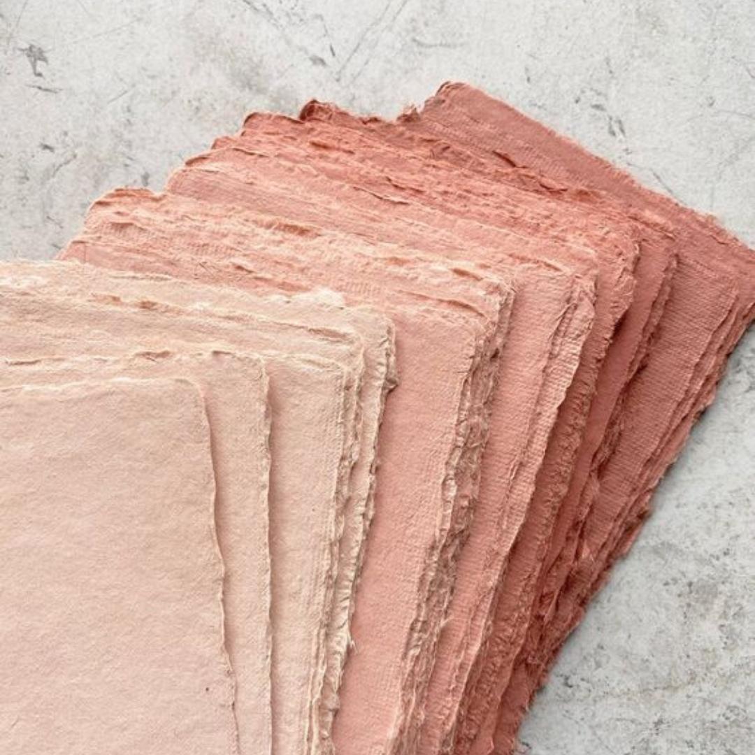 Håndlavet papir i rødlige farver, papiret er lavet af bæredygtige genbrugsmaterialer på en kreativ workshop afholdt af creatør