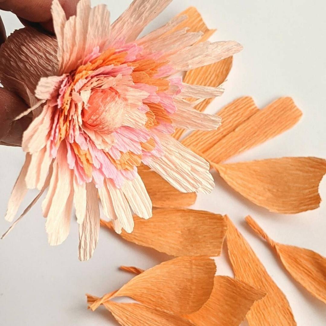 papirblomst i orange og lyserøde farver lavet på en papirblomst workshop til et polterabend